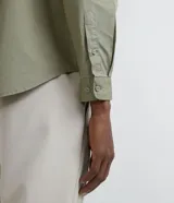 Camisa verde militar de manga larga en sarga de algodón, con cuello clásico, cierre frontal abotonado y dos bolsillos con solapa abotonada en el pecho.