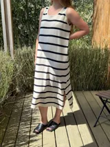 Vestido midi sin mangas de tejido rústico color crudo, con rayas horizontales anchas color negro y tajos laterales.