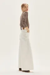 Remera de manga larga a rayas horizontales marrones y blancas, con cuello redondo y corte holgado.