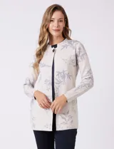Cárdigan de punto marca Sioni, color beige con estampado floral en tonos azules. Presenta escote redondo a la base, cierre frontal con un botón metálico y mangas largas de corte recto.