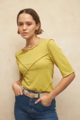 Remera negra de manga tres cuartos, escote redondo y detalle de costuras superpuestas de forma asimétrica.