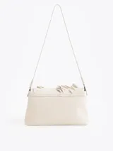 Cartera de hombro negra confeccionada en cuero vacuno, con diseño de solapa frontal decorada con volados de cuero y cierre metálico tipo candado.