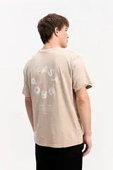 Remera de algodón color beige con efecto lavado, de manga corta y cuello redondo. Cuenta con estampa tipográfica en la espalda con el diseño "FAST DROP".