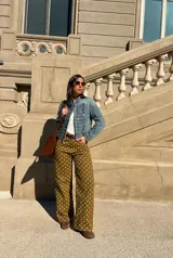 Chaqueta de denim estilo militar, de corte corto, cuello mao y múltiples hileras de botones metálicos frontales.