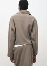 Jersey de cuello solapado y cierre frontal con cremallera corta, de manga larga y diseño holgado.