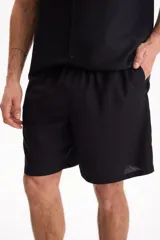 Bermuda de lino negro con cintura elastizada y cordón ajustable.