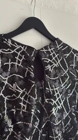 Minivestido negro con lentejuelas y estampado geométrico blanco.