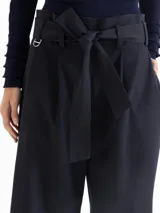 Pantalón culotte azul claro, de tiro alto, con pliegues frontales y cinturón de tela anudado en la cintura. Incluye bolsillos laterales.