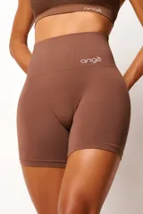 Conjunto deportivo de dos piezas color marrón, compuesto por un top de tirantes finos con textura de microtramas respirables y un short tiro alto con efecto modelador y levanta glúteos.