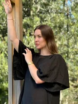 Vestido verde oliva de lino, corte suelto, con mangas abullonadas y volado en el ruedo.