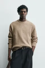 Sweater de punto color beige, de corte relajado, con cuello redondo y diseño texturizado en estructura waffle.