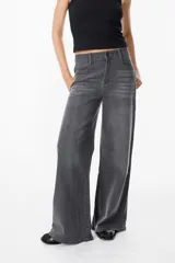 Jean de corte wide leg en color gris con efecto lavado, tiro medio y cierre frontal con botón y cremallera.