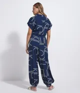 Mono largo Marfinno de color azul marino con estampa geométrica en color blanco, de corte estilo aladín con mangas cortas, cuello camisero, cierre frontal con botones y puños ajustados en los tobillos. Incluye un cinturón de cuerda ajustable en la cintura con nudos y detalles de esferas en las puntas.