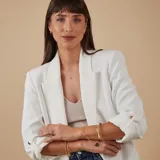 Esclava de alambre redondo en oro 9k, de diseño minimalista, con una medalla colgante que presenta un diseño grabado en forma de estrella con una circonia incrustada.