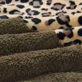 Buzo de polar con cierre frontal parcial, diseño combinado con estampado animal print en la parte superior y color blanco en la parte inferior. Cuenta con bolsillo frontal tipo canguro y mangas largas.