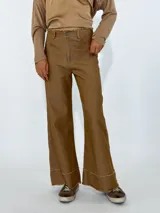 Pantalón de jean negro de corte acampanado con terminación desflecada en ruedo y cintura.