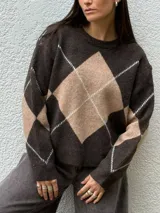 Sweater de punto con diseño de rombos en tonos gris oscuro y gris claro, de corte holgado, cuello redondo y manga larga.