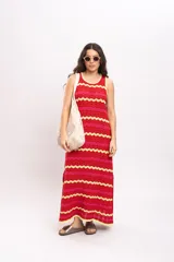Vestido largo de tejido de punto con diseño de rayas en zigzag de colores rojo, fucsia y amarillo. Presenta cuello redondo y diseño sin mangas.