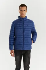 Campera puffer acolchada de color azul marino, con cuello alto y cierre frontal completo. Diseño ligero y versátil, ideal para media estación.