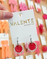 Aros colgantes con aro de acero plateado y dije circular rojo con borde de strass plateado.