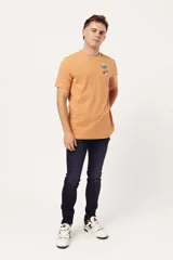 Remera de manga corta color naranja claro con cuello redondo y un pequeño estampado gráfico de temática playera en el pecho izquierdo.