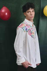 Camisa de corte oversize con mangas largas y puños abotonados. Presenta un diseño bicolor con cuerpo blanco y un canesú delantero con estampado floral multicolor.