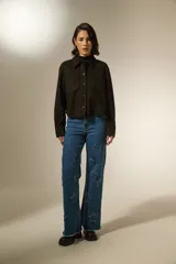 Sobrecamisa de textura gamuzada en color negro, con cuello clásico, cierre frontal de botones y dos bolsillos frontales con solapa.