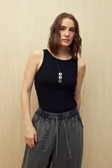 Musculosa blanca de punto acanalado, sin mangas, con cuello a la base y calce al cuerpo.