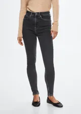 Jeans de corte skinny y tiro alto, confeccionados en tejido denim elástico de algodón. Presentan diseño clásico de cinco bolsillos, trabillas para cinturón y cierre frontal con cremallera y botón.