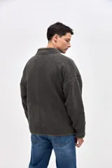 Campera de sherpa con diseño capitoneado en color crema. Presenta cierre frontal completo, cuello alto, bolsillos laterales y un bolsillo en el pecho con cierre en contraste. Incluye detalles en nylon y bordado decorativo en el pecho.