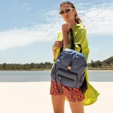 Mochila de nylon color bordó con tapa y broche metálico. Tiene apertura superior con broche, bolsillos internos, bolsillo con cierre metálico al frente y laterales. Incluye asas rígidas de mano y correas regulables para colgar en la espalda.
