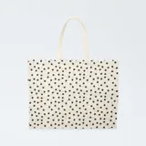 Tote-bag XXL de tela en color blanco con estampado de lunares negros y asas dobles superiores.