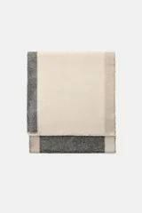 Pañuelo rectangular de diseño color block con franjas en tonos beige, gris y tostado, con bordes deshilachados.