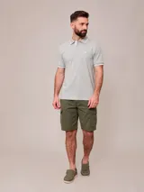 Remera polo blanca de manga corta, con detalles en azul marino en el cuello y los puños, y el logo bordado en el pecho.