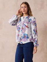 Blusa de gasa estampada con flores, marca Zac & Rachel. Tiene cuello a la base con abertura central con botones y mangas largas abullonadas.