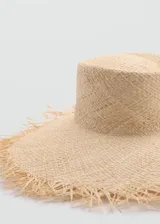 Sombrero de ala ancha confeccionado en fibra natural de rafia, con diseño de copa plana y bordes deshilachados.