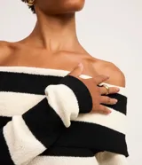 Vestido midi de punto con rayas horizontales blancas y negras, escote bardot y mangas largas.