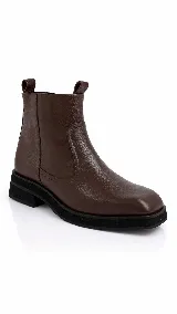 Bota corta de cuero color marrón con punta cuadrada y suela plana de goma negra.