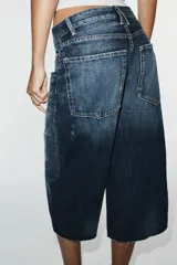 Bermuda de jean tiro medio, corte baggy y diseño holgado con detalle de rotos y cinco bolsillos.