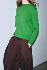 Jersey de punto liso color verde, con cuello redondo y manga larga. Confeccionado en lana suave.