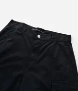 Pantalón cargo de corte mega baggy, color negro, confeccionado en sarga de algodón. Presenta múltiples bolsillos funcionales y un diseño versátil que permite transformar la prenda en bermuda mediante un sistema de ajuste en las piernas.