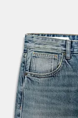 Jeans de corte boyfriend y tiro medio, con diseño de cinco bolsillos, trabillas para cinturón y cierre frontal con botones metálicos. Presenta un lavado clásico con efecto desgastado.