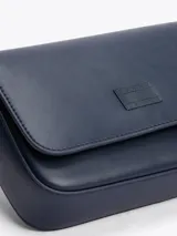 Cartera bandolera Tommy Jeans de color azul marino, de diseño estructurado con acabado liso, solapa frontal con cierre magnético y parche con el logo de la marca grabado en la parte delantera. Cuenta con correa ajustable para el hombro.