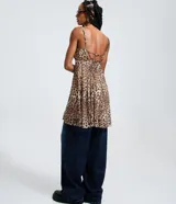 Vestido corto de corte godê confeccionado en tejido de tule con estampado animal print de leopardo. Presenta breteles finos, escote en V y diseño fluido con forro interno.