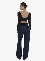 Jean de tiro alto con silueta wide leg y diseño de doble cintura superpuesta en contraste. Confeccionado en denim de algodón, presenta un calce holgado, bolsillos funcionales y cierre frontal con botón y cremallera.