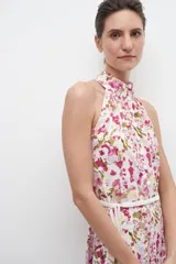 Vestido corto con estampado floral multicolor, cuello halter y falda acampanada. Incluye cinturón blanco con flecos.