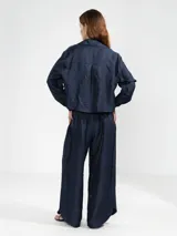 Pantalón de lino italiano con hilo metalizado color azul marino, de corte recto y talle medio, con cintura elástica en la parte posterior y bolsillos delanteros.