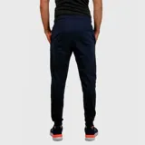 Pantalón deportivo tipo jogging de hombre, color azul marino, con cintura ajustable con cordón y puños elásticos en los tobillos. Presenta un pequeño logo bordado en la pierna izquierda.