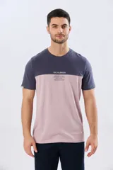 Remera de algodón y poliéster de corte clásico, con diseño en bloques de color negro en la parte superior y gris melange en la inferior. Presenta cuello redondo, mangas cortas y un pequeño estampado tipográfico en el pecho.