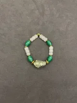 Pulsera elástica de piedras naturales que combina cuentas de cuarzo blanco, cuentas verdes y una piedra central irregular en tono verde claro, con detalles de separadores metálicos dorados.